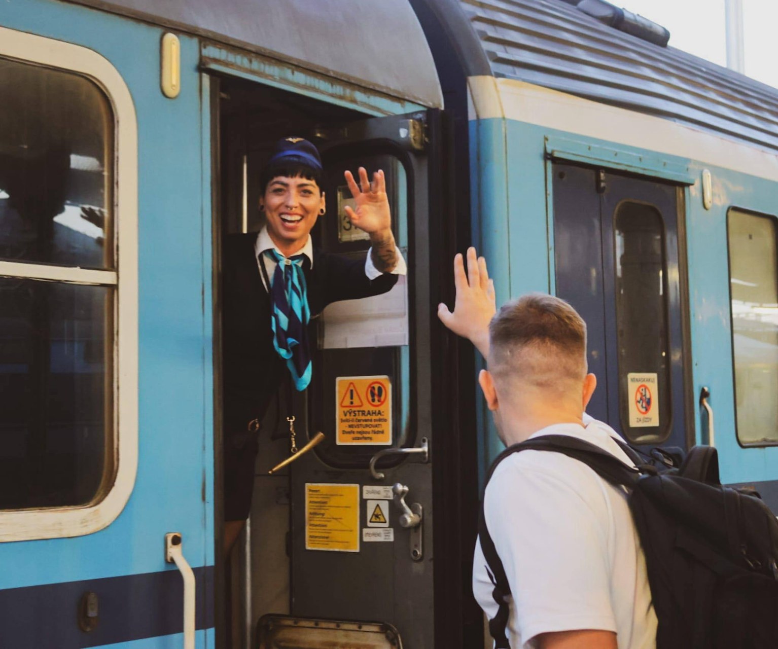 Průvodčí vítá cestující u historického vozu